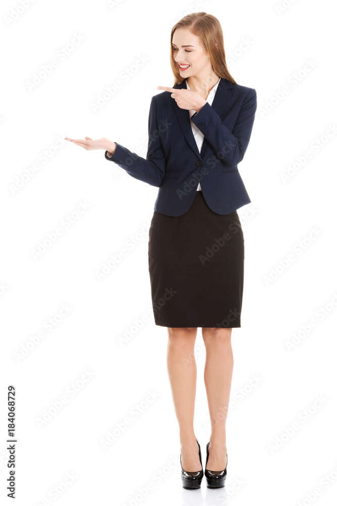 Beautiful caucasian business woman pointing on copy space on her side. Beautiful caucasian business woman pointing on copy space on her side.