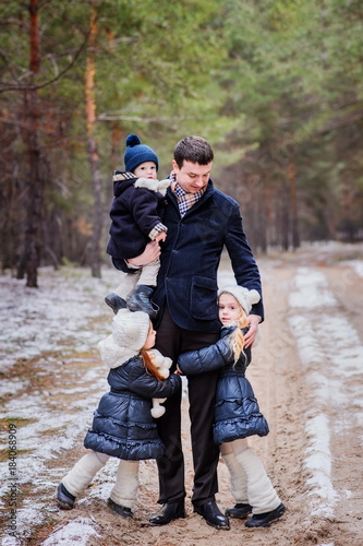 The family is resting in the forest. People stroll in the winter forest