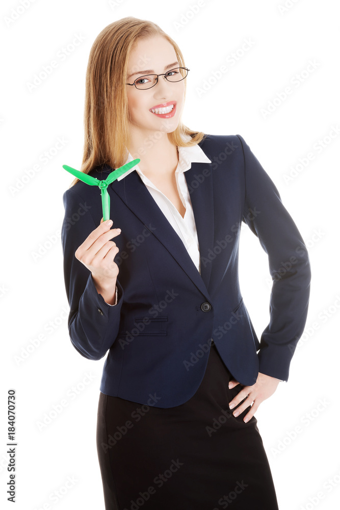 Beautiful business woman holding small green propeller. Beautiful business woman holding small green propeller.