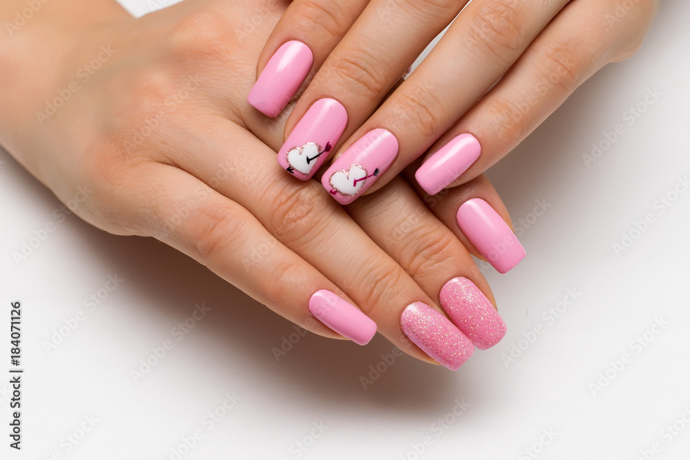 gently pink manicure with sparkles with painted hearts and arrows on square long nails
