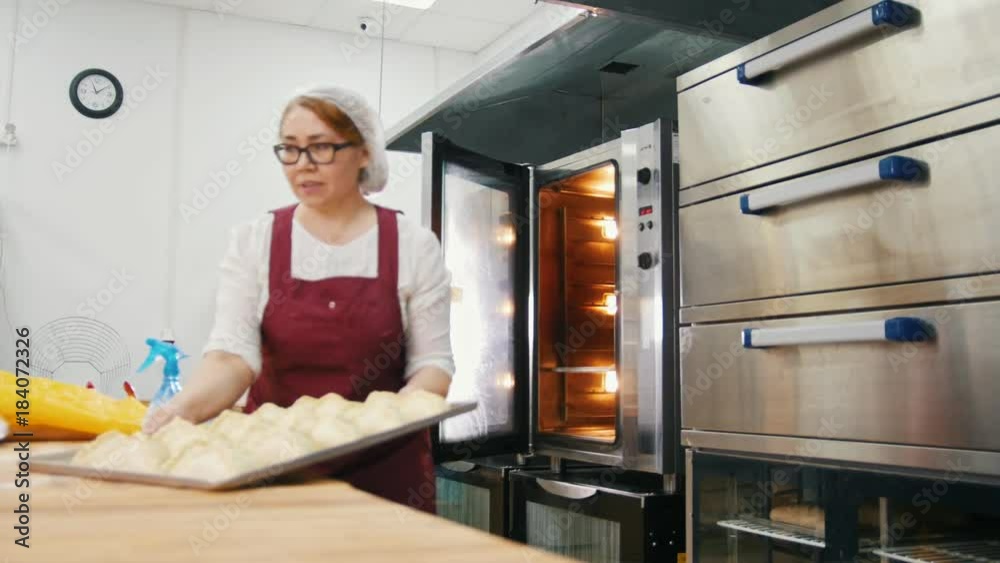 The cook puts the pies in the oven in the bakery The cook puts the pies in the oven in the bakery