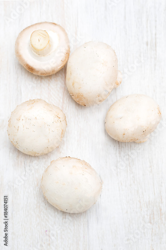 Champignons on a white wooden board. Vertical photo