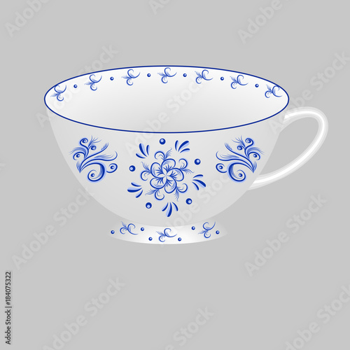 Decorative porcelain tea cup ornate with blue floral pattern in traditional Russian style Gzhel.