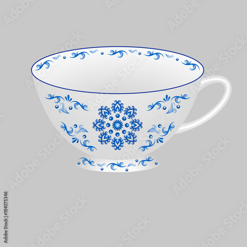 Decorative porcelain tea cup ornate with blue floral pattern in traditional Russian style Gzhel.