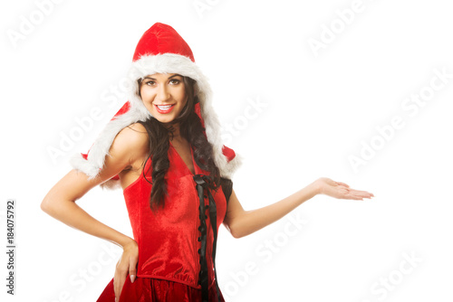 Portrait of woman holding something invisible in right hand wearing santa clothes 