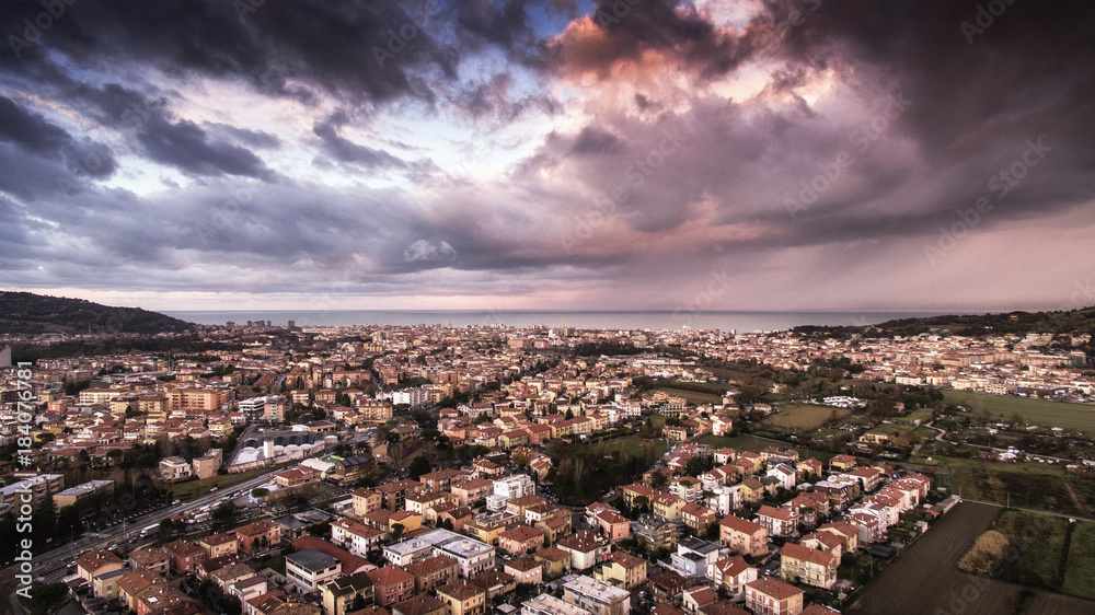 ITALY, Pesaro December 2017 - aerial view of the city with stormy houses, streets, hills and storm clouds