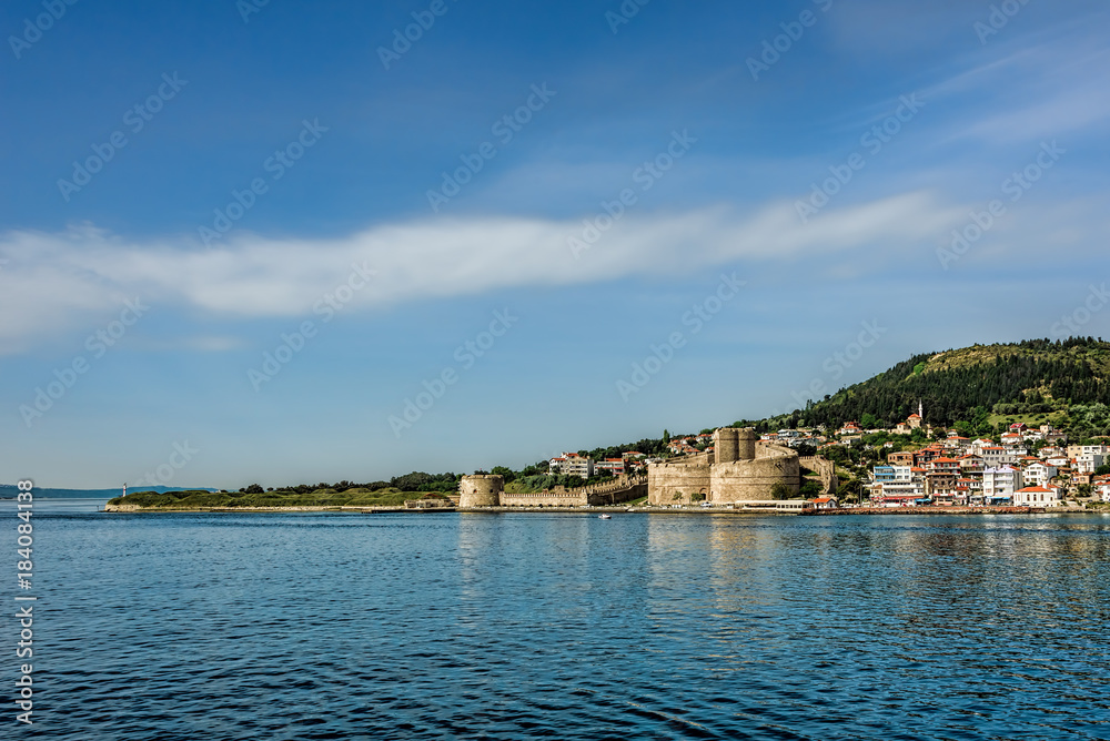 Ancient castle on the seashore under clear blue skies with scatt
