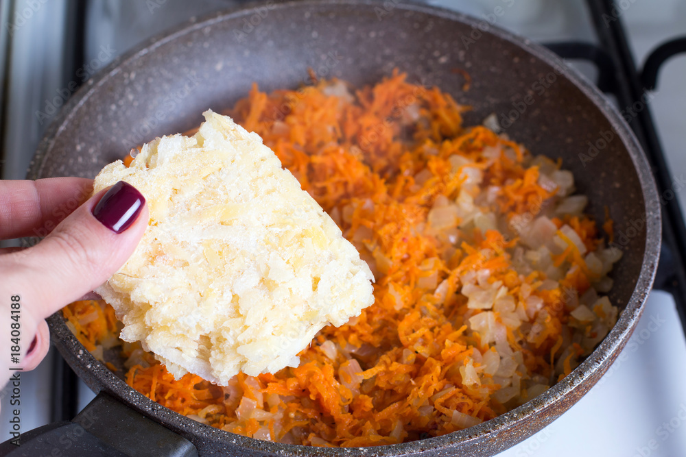 Adding grated celery root into frying pan Adding grated celery root into frying pan