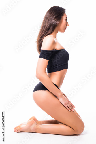 Perfect Body, Beautiful Woman. Full length portrait. Model girl with beautiful body - legs, arms, shoulders, sitting on a floor. Health and beauty woman in black underwear.