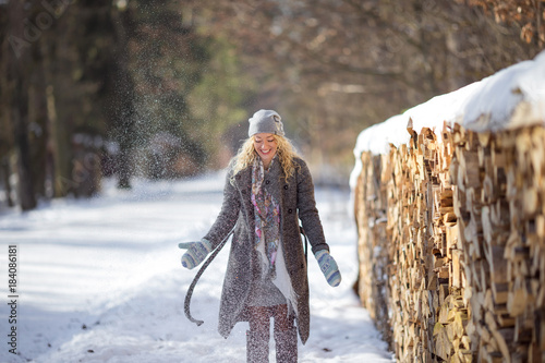 Junge hübsche glückliche Frau wirft Schnee photo