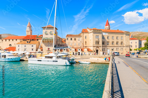 View of historic buildings and catamaran boat in Trogir town from bridge over canal, Dalmatia, Croatia