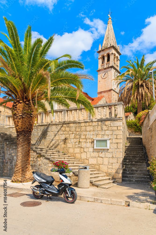 Naklejka premium Scooter parking in front of a church in Splitska village, Brac island, Croatia