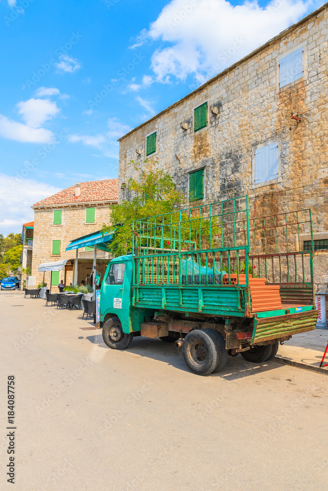Naklejka premium SPLITSKA PORT, BRAC ISLAND - SEP 7, 2017: delivery truck parking in picturesque Splitska village on Brac island, Dalmatia, Croatia.