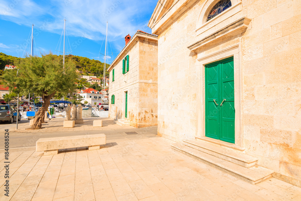 Church facade with green door in Pucisca port on Brac island, Dalmatia, Croatia