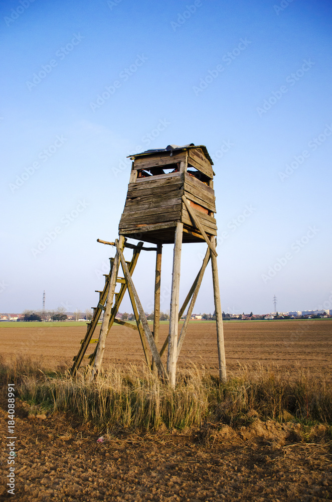 Naklejka premium Hunter lookout tower in the middle of field