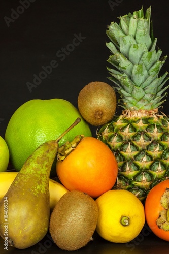 Different fruits on a black kitchen table. Food for athletes. Vitamins against colds and flu.