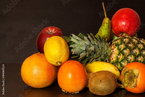 Fototapeta Naklejka Na Ścianę i Meble -  Different fruits on a black kitchen table. Food for athletes. Vitamins against colds and flu.