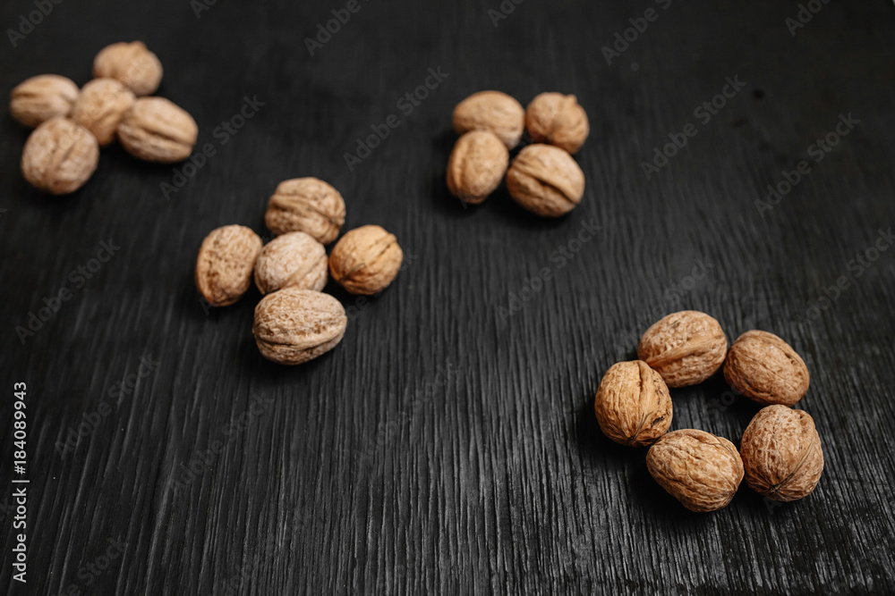 Lots of fresh nuts on a black wooden background. Best practices for designer. A beautiful design from the nuts Lots of fresh nuts on a black wooden background. Best practices for designer. A beautiful design from the nuts
