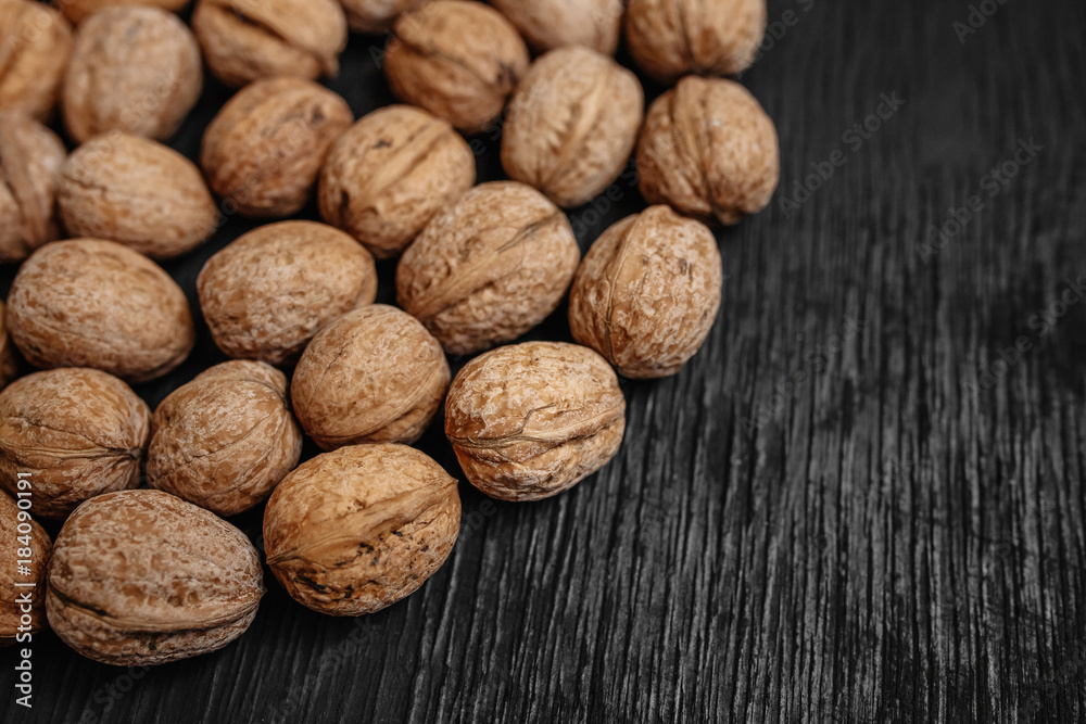 Lots of fresh nuts on a black wooden background. Best practices for designer. A beautiful design from the nuts