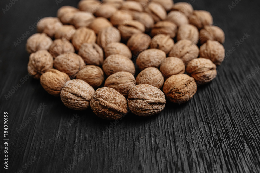 Lots of fresh nuts on a black wooden background. Best practices for designer. A beautiful design from the nuts Lots of fresh nuts on a black wooden background. Best practices for designer. A beautiful design from the nuts