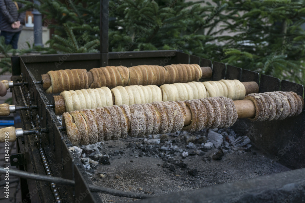 Traditional street food of country Czech Republic. Preparing of Trdelnik - traditional czech bakery. Czech sweet pastry called Trdlo. Trdelnik baking on the street market in Pirna.