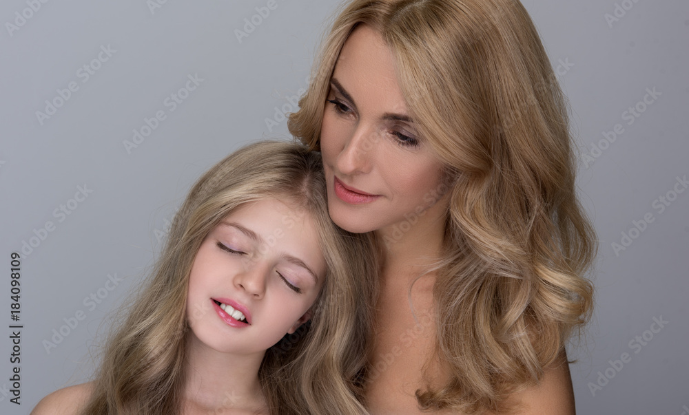 Maternal love. Portrait of lovely daughter is standing with closed eyes