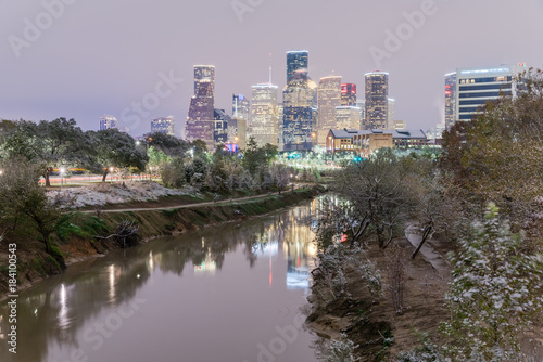 Unusual snowfall along Bayou River bank with downtown Houston, Texas, USA skylines city lights reflection at sunrise/twilight. Snow is extremely rarely in Houston and happen only 35 times since 1895 photo