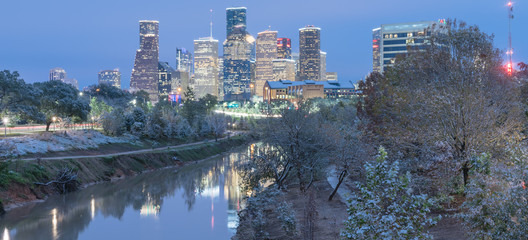Panorama view unusual snowfall along Bayou River bank with downtown Houston, Texas, USA skylines city lights reflection at sunrise/twilight. Snow is extremely rarely and happen only 35 time since 1895