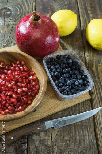 Pomegranate grains in a wooden bowl closeup