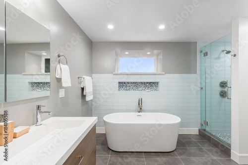 Luxury bathroom interior with an oval bathtub stone tiles and with glass shower