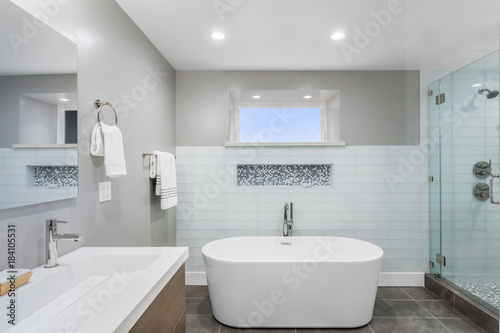 Luxury bathroom interior with an oval bathtub stone tiles and with glass shower