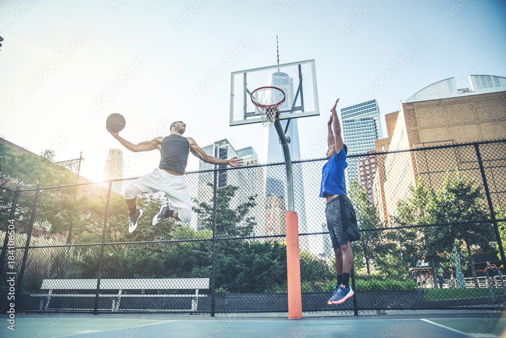 Naklejka premium Basketball player playing outdoors