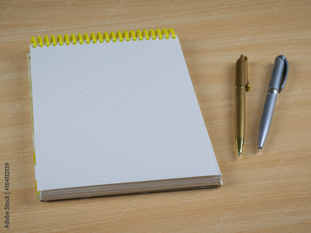 Two ballpoint pens with notebook on a wooden table. Place for your text. Two ballpoint pens with notebook on a wooden table. Place for your text.