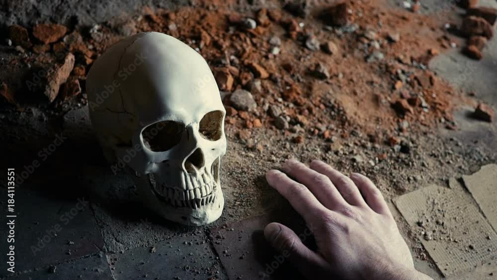 the falling hand of a dead addict with a syringe against the background of the skull slow motion the falling hand of a dead addict with a syringe against the background of the skull slow motion