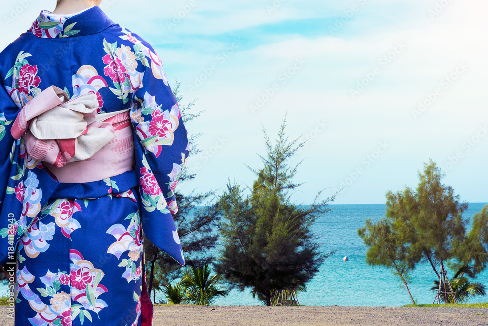 Woman in traditional Japanese kimonos walking to the beach in Japan Woman in traditional Japanese kimonos walking to the beach in Japan