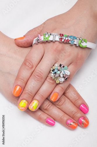 Woman with orange, pink and yellow manicured nails 