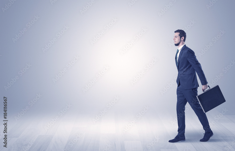 Businessman walking in front of an empty wall Businessman walking in front of an empty wall