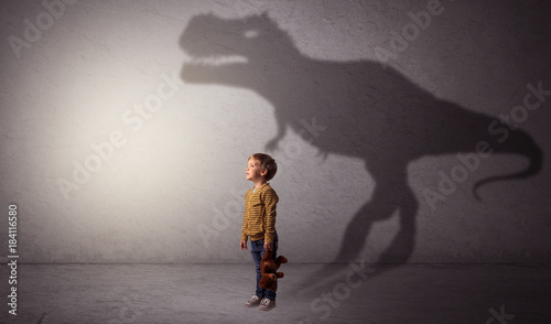 Dinosaurus shadow behind cute boy