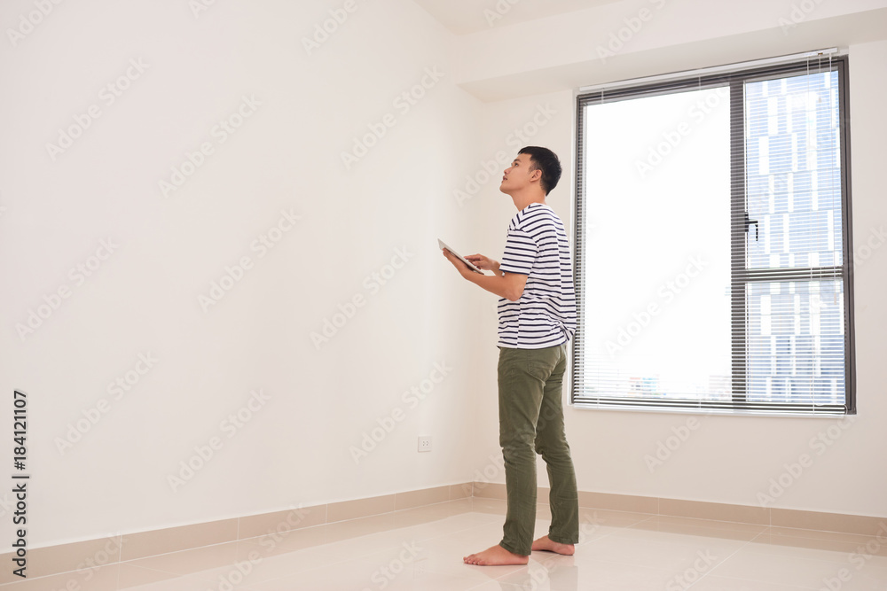 dream of a new home, a young man holding a tablet and plans new home dream of a new home, a young man holding a tablet and plans new home
