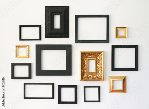 Multiple many blank small picture frames on white wall