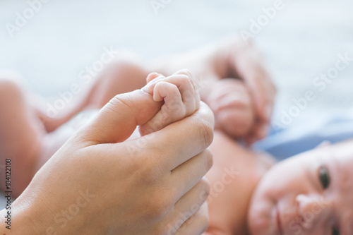 cute newborn baby hold mother by the thumb. happy motherhood. family values.