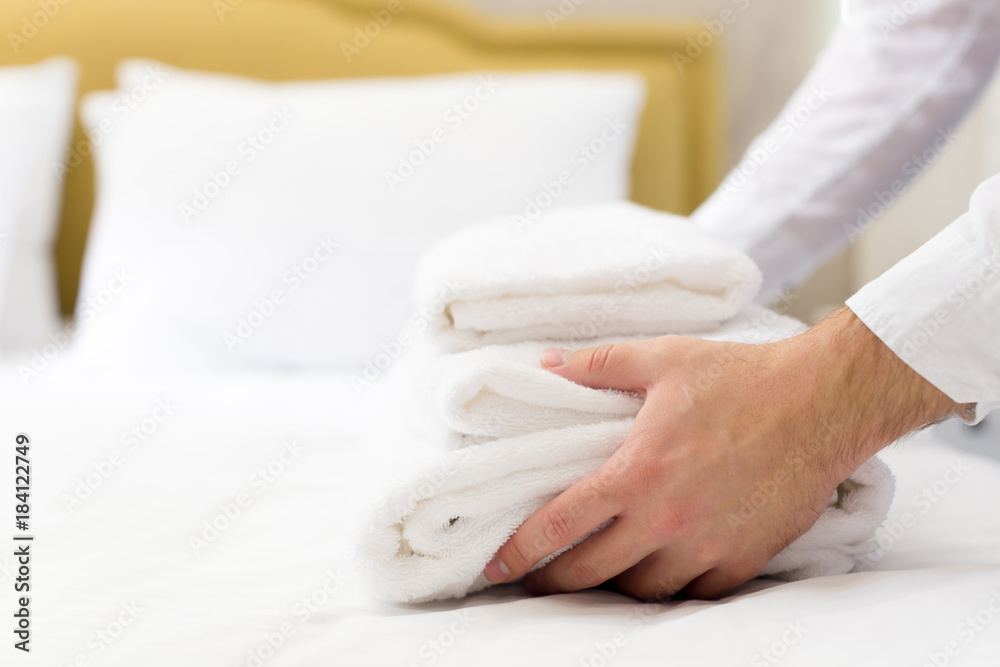 hotel staff setting up pillow on bed