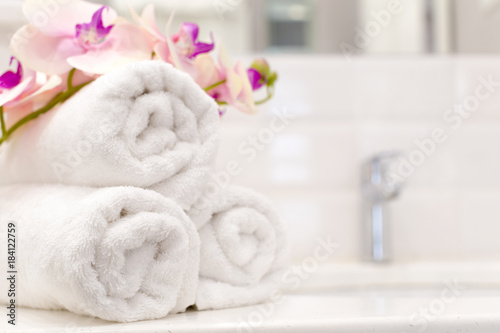 Stack of towels with flower decor in a hotel room © fotofabrika
