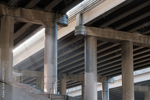 Light filters through and exposes the underside of a concrete freeway