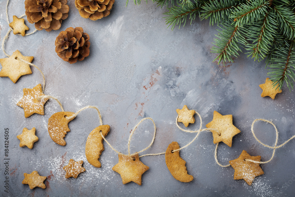 Homemade shortbread star shape sugar with sugar powder and branch of fit-tree on thread over blue texture surface. Selektive focus. Christmas or New Year background. Top view with space. Homemade shortbread star shape sugar with sugar powder and branch of fit-tree on thread over blue texture surface. Selektive focus. Christmas or New Year background. Top view with space.