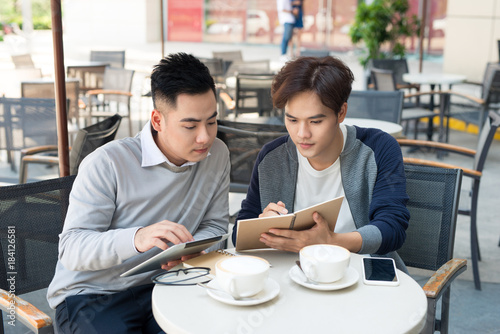 portrait of two asian Business people Working with tablet In cafe