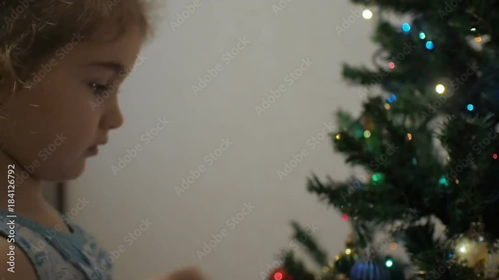 Cute little girl decorates the Christmas tree. Cute little girl decorates the Christmas tree.