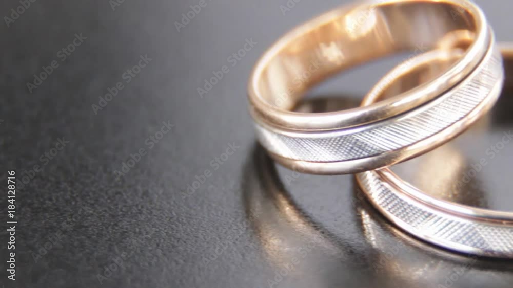 Two beautiful rings engraved with white and yellow gold on a black background Two beautiful rings engraved with white and yellow gold on a black background