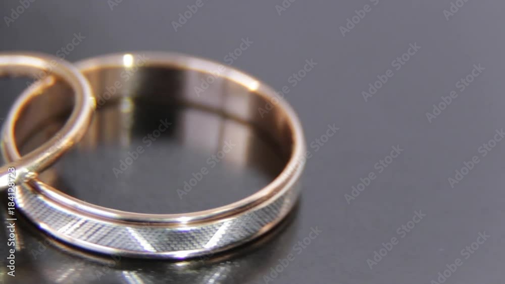 Two beautiful engagement rings engraved with white and yellow gold and with stones jade on a black background Two beautiful engagement rings engraved with white and yellow gold and with stones jade on a black background