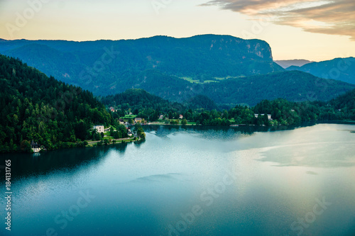 Evening views on the lake Bled with the famous Pilgrimage Church of the Assumption of Maria and Bled Castle and Julian Alps at background